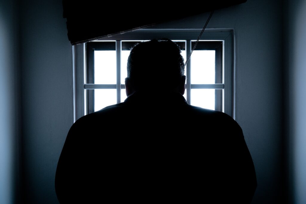 Silhouette of man in prison cell